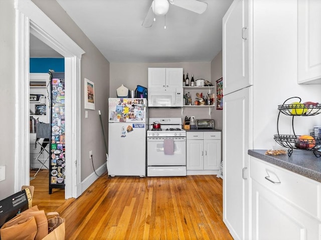 kitchen with white appliances, light wood finished floors, open shelves, white cabinets, and dark countertops