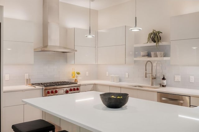 kitchen featuring pendant lighting, sink, white cabinetry, stainless steel dishwasher, and wall chimney exhaust hood