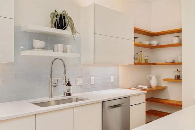 kitchen with sink, backsplash, white cabinets, and dishwasher