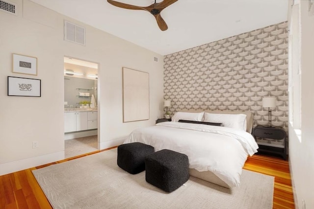 bedroom featuring ensuite bath, ceiling fan, and light hardwood / wood-style flooring