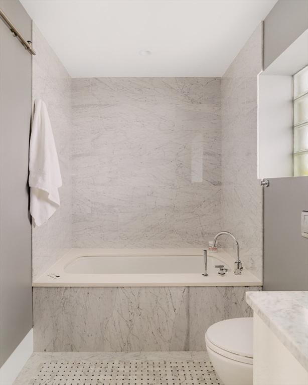 bathroom with tiled tub, vanity, tile walls, and tile patterned floors