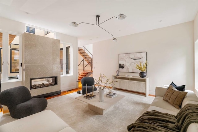 living room with a tiled fireplace and light hardwood / wood-style flooring