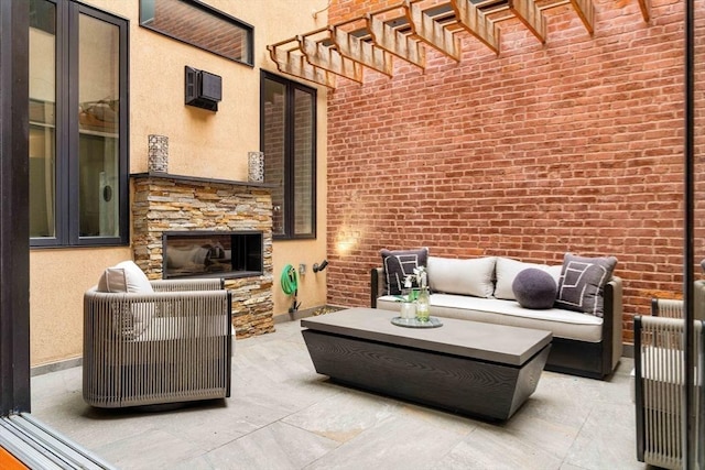 view of patio with an outdoor living space with a fireplace