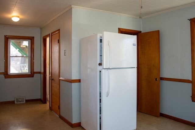 kitchen with crown molding and white fridge