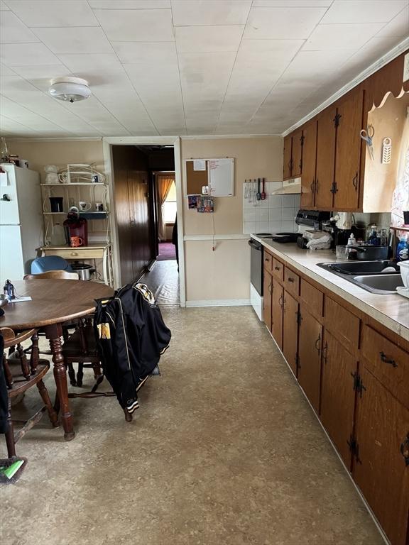 kitchen featuring electric range, sink, and white fridge