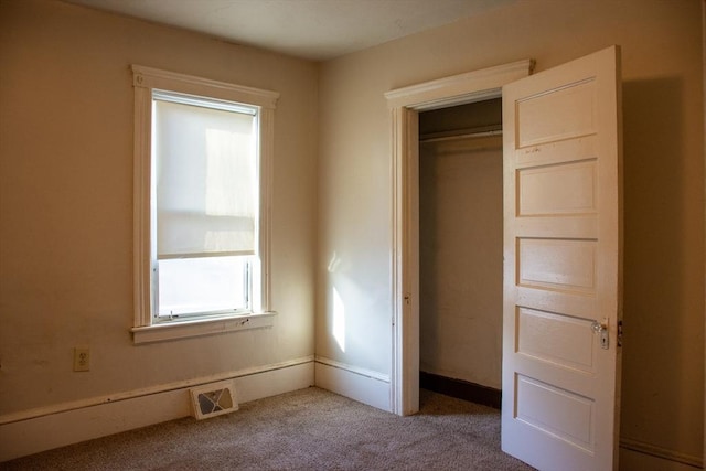 unfurnished bedroom featuring a closet and light carpet