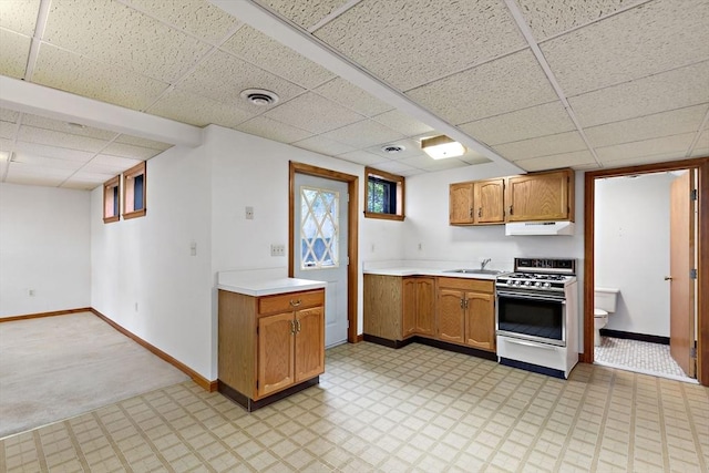 kitchen with range with gas cooktop, a drop ceiling, a sink, light countertops, and under cabinet range hood
