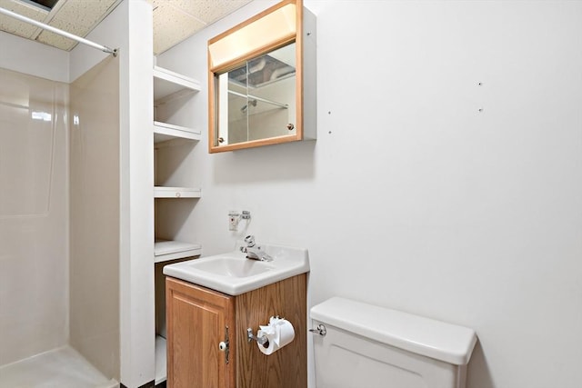 full bath with toilet, a shower, vanity, and a drop ceiling
