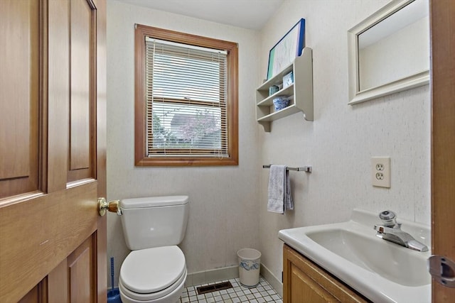 bathroom featuring vanity, toilet, baseboards, and tile patterned flooring