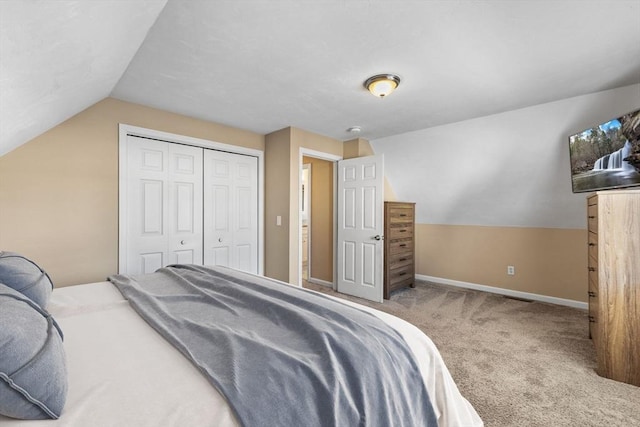 bedroom with vaulted ceiling, carpet floors, and a closet