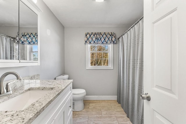 bathroom with vanity, a healthy amount of sunlight, and toilet