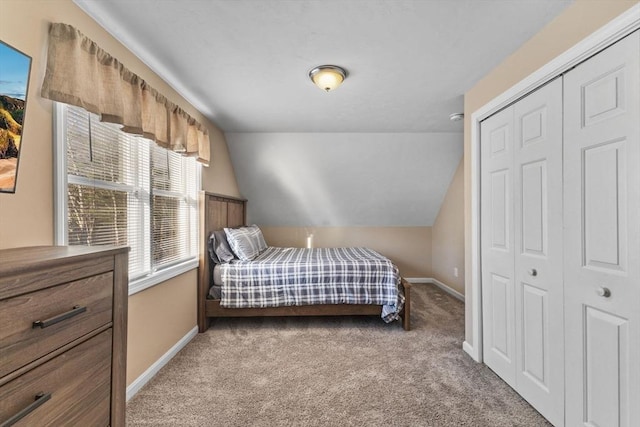 carpeted bedroom with vaulted ceiling and a closet