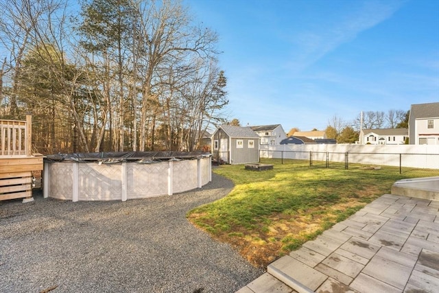 view of yard with a storage shed and a covered pool