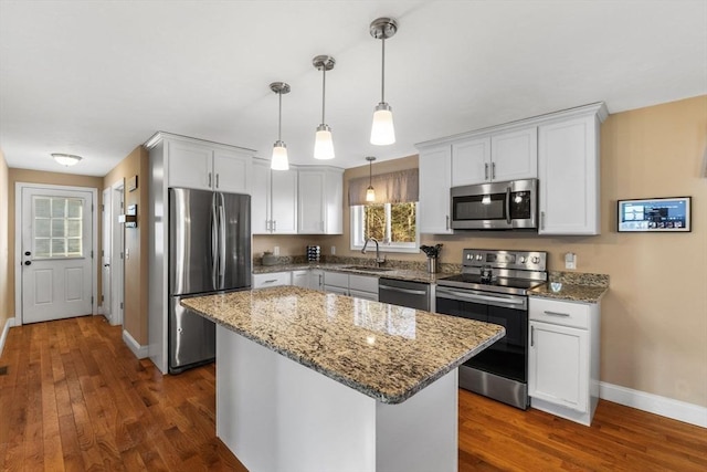 kitchen with white cabinetry, sink, a center island, pendant lighting, and appliances with stainless steel finishes