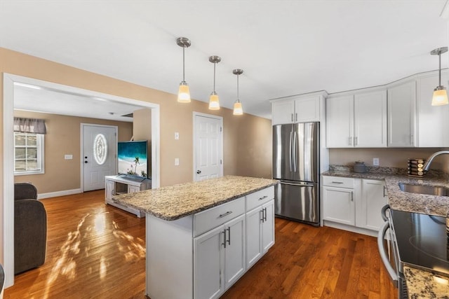 kitchen featuring white cabinetry, hanging light fixtures, dark hardwood / wood-style flooring, a kitchen island, and appliances with stainless steel finishes