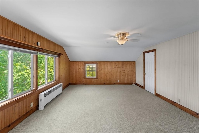 49 Bay View Dr, Shrewsbury, MA 01545 - additional living space featuring radiator heating unit, wooden walls, vaulted ceiling, ceiling fan, and light colored carpet
