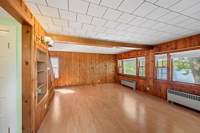 49 Bay View Dr, Shrewsbury, MA 01545 - unfurnished living room with radiator, wooden walls, and light wood-style flooring