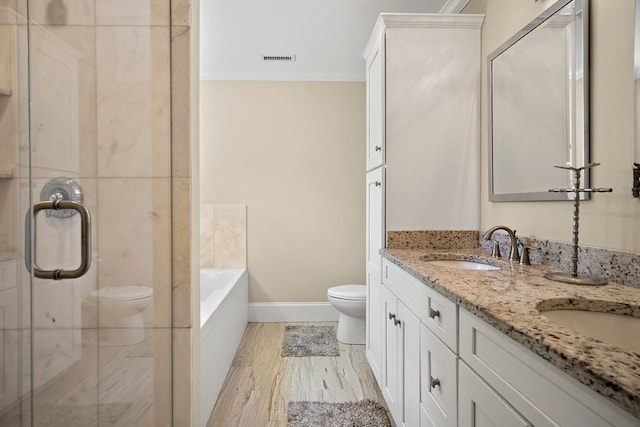 11 Broadway St Unit 2, Stoneham, MA 02180 - full bathroom with double vanity, ornamental molding, a garden tub, a shower stall, and wood finished floors
