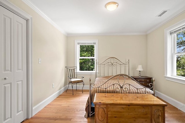 11 Broadway St Unit 2, Stoneham, MA 02180 - bedroom featuring multiple windows, light wood-style floors, and ornamental molding