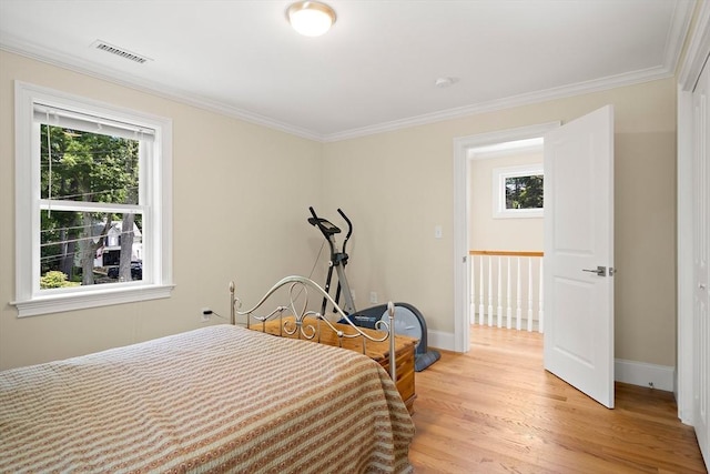 11 Broadway St Unit 2, Stoneham, MA 02180 - bedroom with multiple windows, crown molding, and light wood-style floors