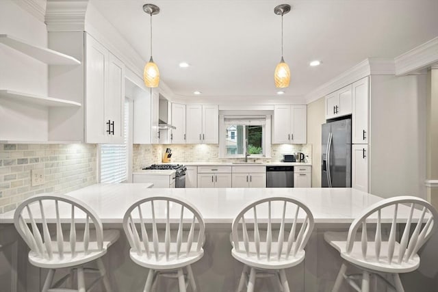11 Broadway St Unit 2, Stoneham, MA 02180 - kitchen featuring stainless steel appliances, light countertops, a peninsula, backsplash, and white cabinets