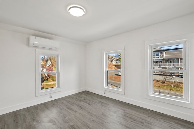 empty room featuring dark hardwood / wood-style flooring and a wall mounted AC