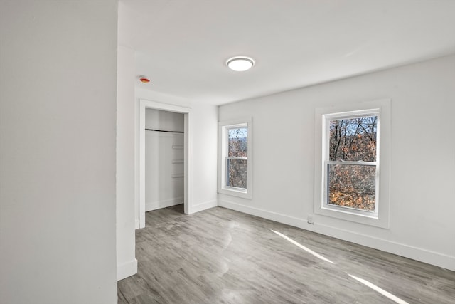 unfurnished bedroom with hardwood / wood-style floors and a closet