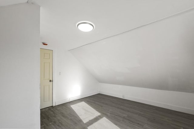 bonus room with dark hardwood / wood-style floors and vaulted ceiling