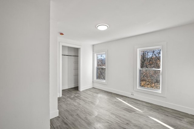 unfurnished bedroom featuring wood-type flooring and a closet