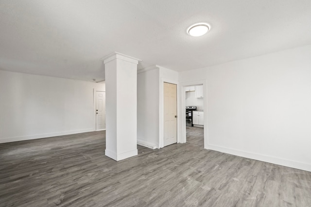 unfurnished living room with wood-type flooring and ornate columns