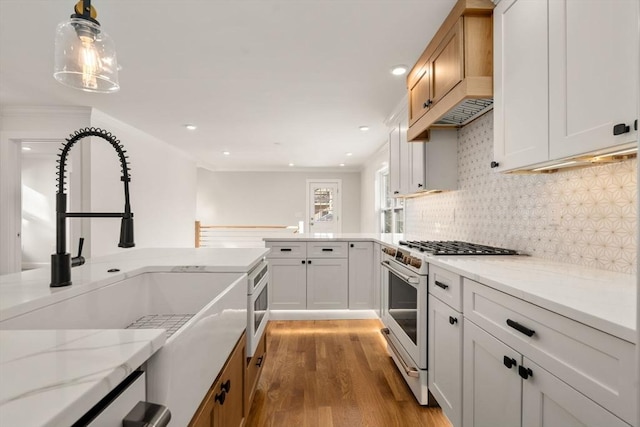 kitchen featuring white cabinets, hanging light fixtures, and range with gas stovetop