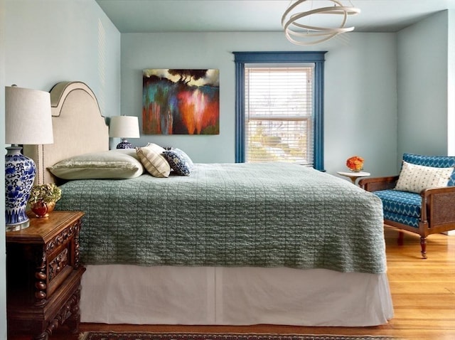 bedroom with wood finished floors and a chandelier