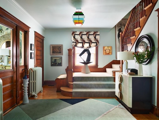 interior space featuring radiator heating unit, wood finished floors, and crown molding