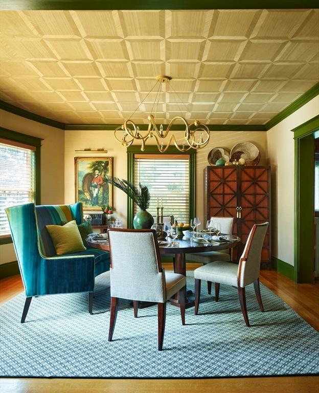 dining space featuring a chandelier, ornamental molding, wood finished floors, and baseboards
