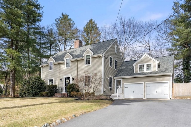 view of front of property with an attached garage, a front lawn, fence, a chimney, and driveway