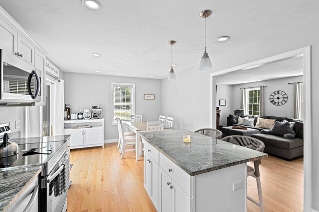 111 Spruce St, Middleboro, MA 02346 - kitchen featuring appliances with stainless steel finishes, a kitchen breakfast bar, white cabinets, light wood-style floors, and recessed lighting