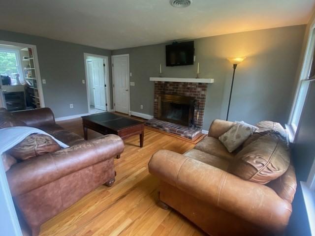 4 Erin Ln, Norfolk, MA 02056 - living room with wood finished floors, a brick fireplace, and baseboards