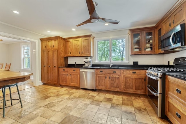 kitchen featuring brown cabinets, stainless steel appliances, a healthy amount of sunlight, and a sink