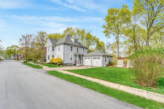 view of front of house with concrete driveway, a front yard, and a garage