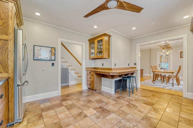 kitchen featuring glass insert cabinets, brown cabinetry, freestanding refrigerator, radiator heating unit, and recessed lighting