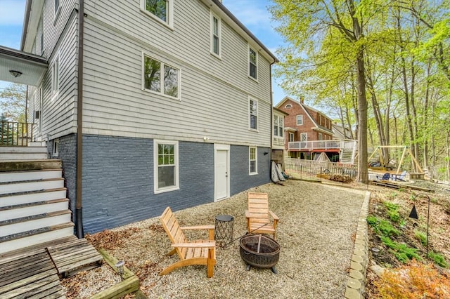 rear view of house featuring stairway and an outdoor fire pit