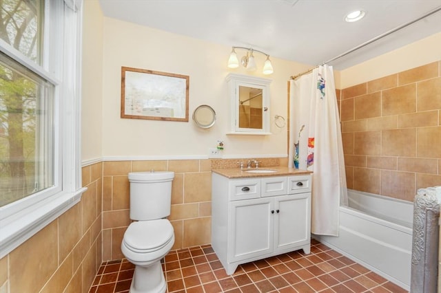 bathroom with tile walls, tile patterned flooring, vanity, toilet, and shower / tub combo with curtain