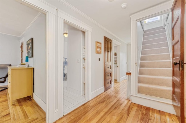 interior space with crown molding, stairway, baseboards, and light wood finished floors
