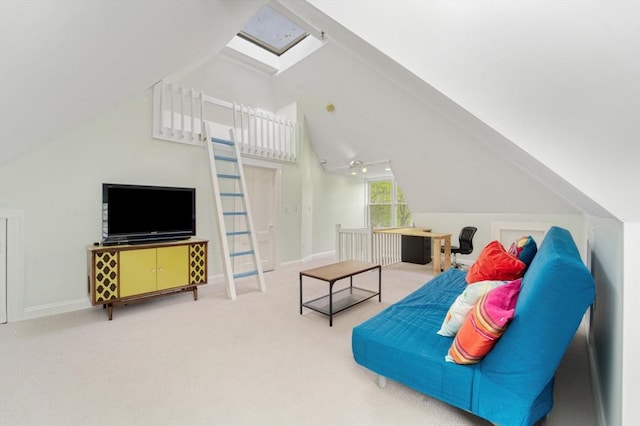 carpeted living area featuring baseboards and lofted ceiling with skylight