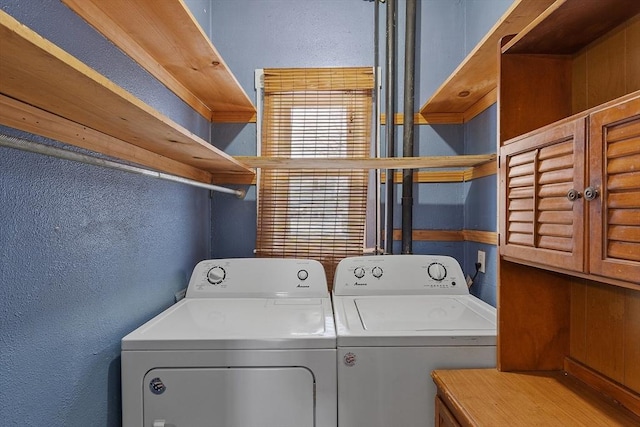 washroom with washing machine and dryer, laundry area, and a textured wall