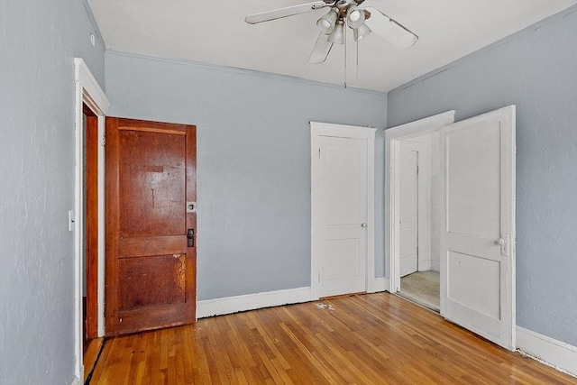 unfurnished bedroom with light wood-type flooring, baseboards, and a ceiling fan