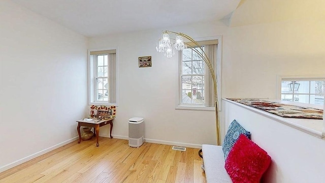 dining space featuring a chandelier, baseboards, visible vents, and light wood-style flooring