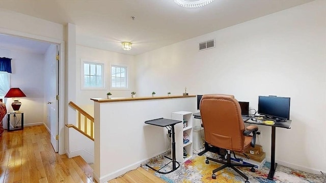 home office with wood finished floors, baseboards, and visible vents