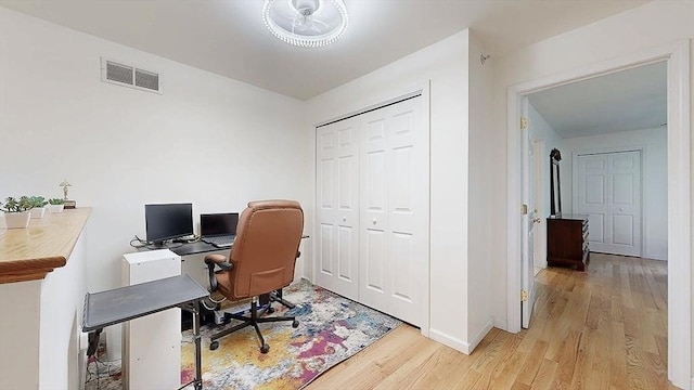 office area featuring visible vents, light wood-style flooring, and baseboards