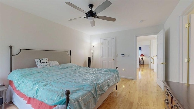 bedroom featuring light wood-style floors, ceiling fan, and baseboards